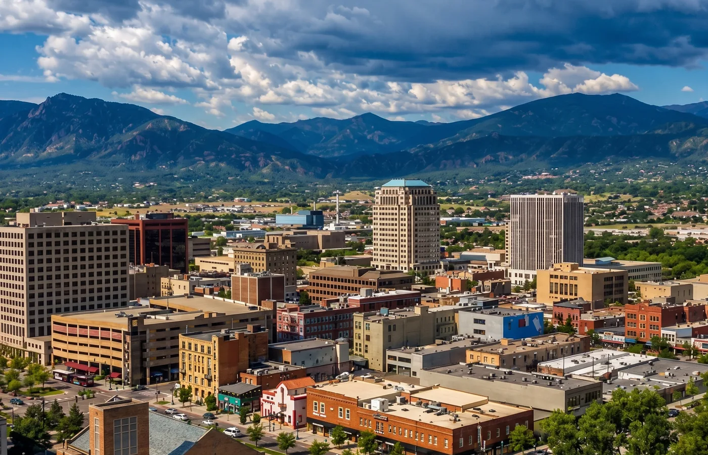 Elevated view of downtown Colorado Springs with high-rise buildings and the Front Range behind