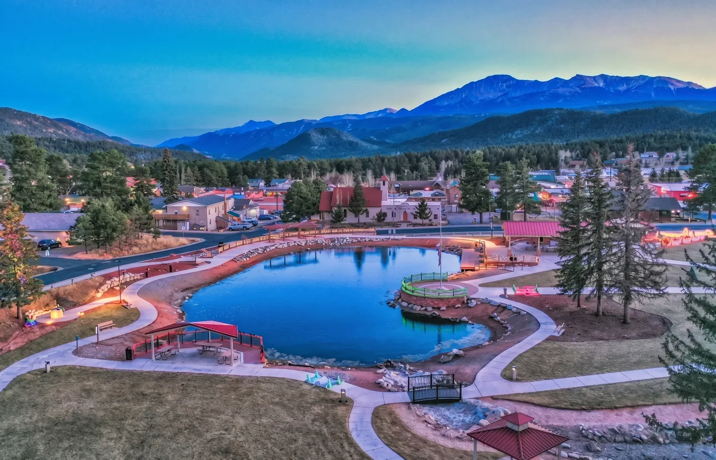 Evening view of Woodland Park, Colorado with the Memorial Park pond, downtown, and Pikes Peak in the distancev